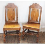 A pair of 18th century oak chairs, with later marquetry inlaid splats,