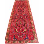 A Caucasian wool runner, worked with an all over geometric design against a red ground,