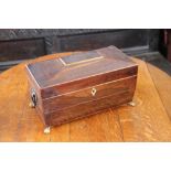 A regency rosewood sarcophagus shaped tea caddy, (lacking glass liner), on later brass paw feet,