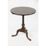 A George III mahogany tilt top occasional table, with circular top on a turned column,