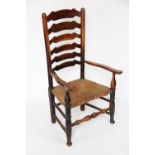 A 19th century ash and elm ladder back chair, with serpentine arms and rush seat,