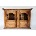 A 17th century style hanging oak food cupboard, two doors with spindle arched apertures,