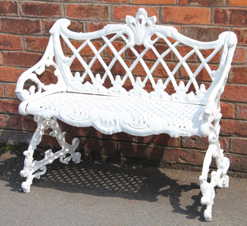 A Coalbrookdale style cast iron garden bench, with trellis back and foliate scroll frame,