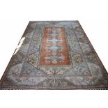 A Turkish Milas wool carpet, worked with geometric foliate motifs in pale colours,