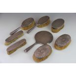 A collection of silver backed dressing table brushes, to include; a pair of hair brushes,