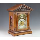 A late Victorian carved walnut eight day mantel clock,