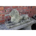 A reconstituted stone garden recumbent lion,