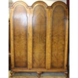 A Warring and Gillow walnut triple dome top wardrobe, with panelled doors, on cabriole legs,