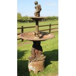 A cast iron garden fountain, modelled with a cherub below a circular pool, on dolphin base,