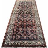 A Caucasian wool runner, worked with an all over foliate design against a deep blue ground,