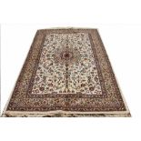 A Kashmir rug, worked with central foliate motif against a ivory ground,