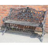 A Coalbrookdale style cast iron garden bench, with foliate scroll frame and wood slat seats,