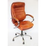 A tan leather and chrome office desk chair, with curved back and pivot base,