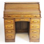 An American oak roll top desk, with tambour enclosing a compartmented interior,