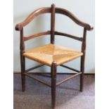 A stained beech childs corner chair, with rush seat, on turned legs,