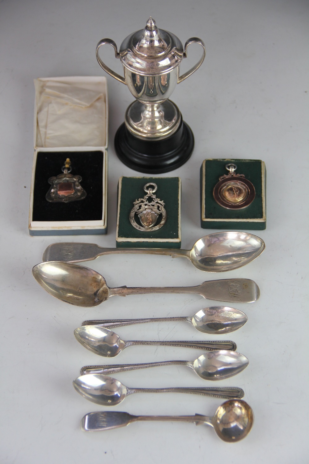 Three assorted silver and gilt medallions including cricket examples, assorted small silver spoons,