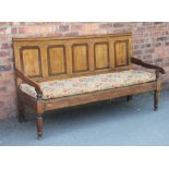 A George III oak and mahogany settle, with five panel back above a panelled solid seat,