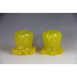 A pair of Edwardian vaseline yellow glass light shades, moulded detailing with frilled rim,