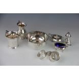 A silver three piece condiment set, Birmingham 1925, three silver napkin rings, a silver milk jug,