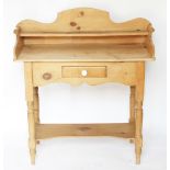 A pine wash stand, with raised single shelf back, above a drawer, on turned legs with under tier,