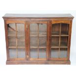 A modern oak three section low bookcase, with astragal glazed doors enclosing shelves,