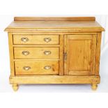 A pine dresser base, with three drawers and cupboard door, on turned legs,