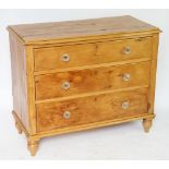 A pine chest, of three long drawers with glass handles, on tuned legs,