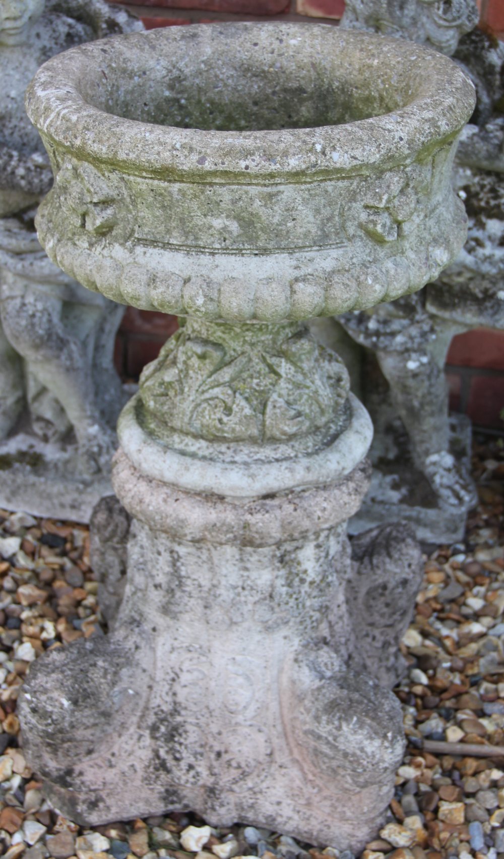 A reconstituted stone bird bath, with circular top on a scroll moulded base,