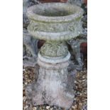 A reconstituted stone bird bath, with circular top on a scroll moulded base,