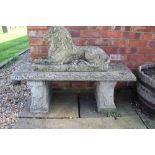 A reconstituted stone garden bench, on scroll moulded ends,
