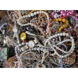 An assortment of costume jewellery, including necklaces, brooches, with a silver bangle,