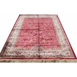 A Kashmir rug, worked with an all over floral design against a red ground,