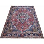 A Caucasian hand woven wool rug, worked with a central geometric medallion against a blue ground,