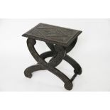 A late Victorian carved oak X frame stool, with rectangular top,