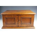 An oak canteen, with engraved plaque to the top dated 1915, the two door cabinet,