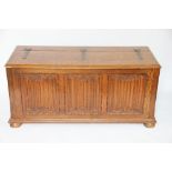 A carved oak blanket chest, with linen fold carved front, on turned feet,