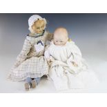 A wax moulded baby doll, early 20th century, with wax head and hands, glass eyes and cloth body,