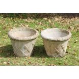 A pair of reconstituted stone circular garden planters, with trellis detailing,