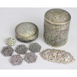 An Indian white metal cylindrical jar and cover, embossed with busy scrolling floral designs, 6.