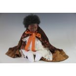 A Margaret Glover black poured wax doll circa 1970's, with glass eyes, wax limbs and cloth body,