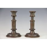 A pair of early 19th century English bronze candlesticks, cast with bands of bound fluted bands,