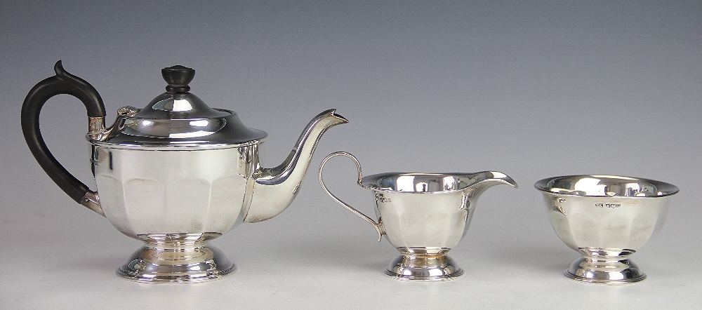 A silver three piece tea service, Viners Ltd, Sheffiled 1937, of faceted circular, pedestal form,