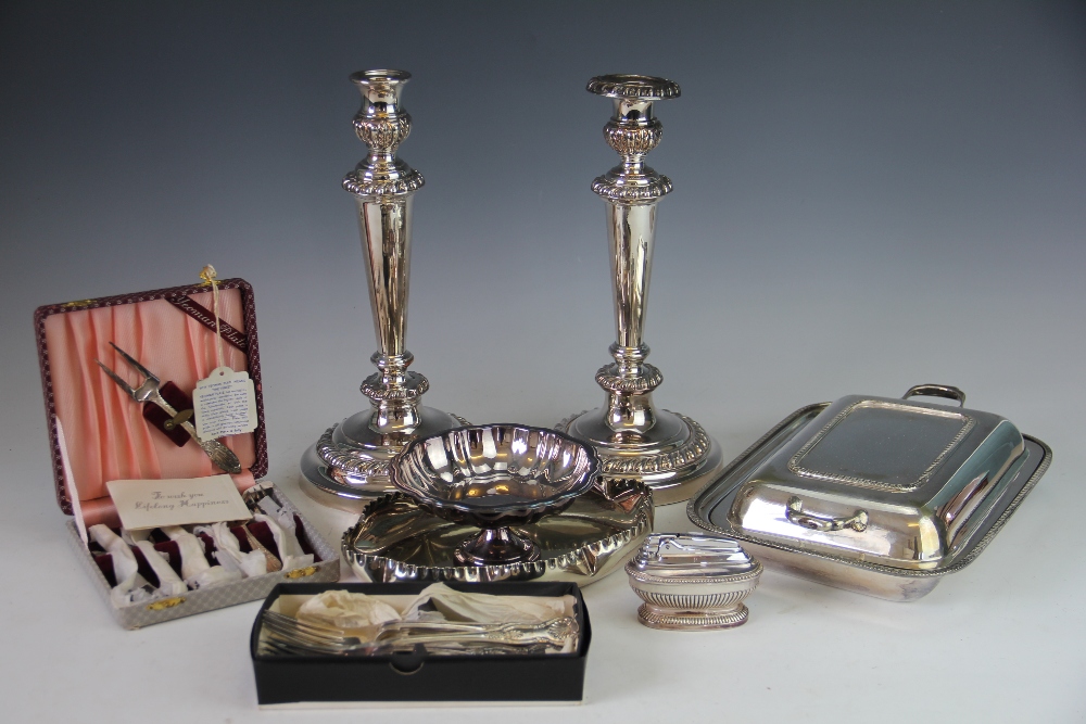 A large collection of silver plate to include a pair of candlesticks and assorted cutlery,