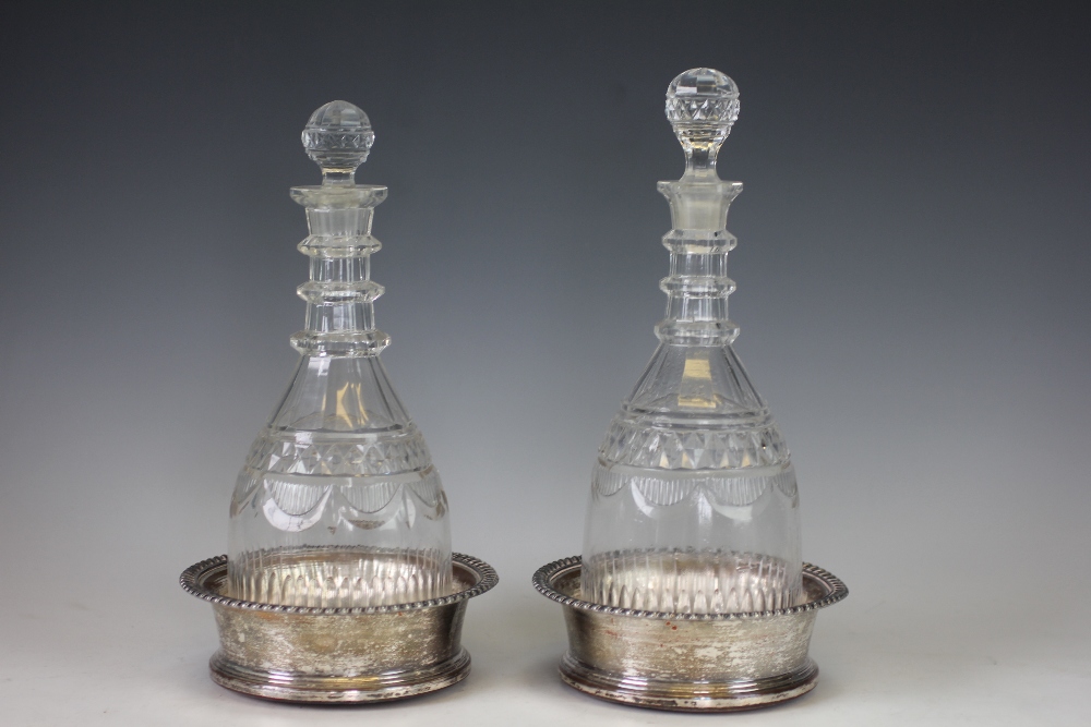 A near pair of decanters and silver plated bottle coasters, 19th century,
