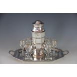 An Art Deco silver plated cocktail shaker and twin handled stand,