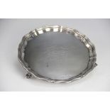 A silver waiter, Viners Ltd, Sheffield 1938, with pie crust rim and raised on three scroll feet,