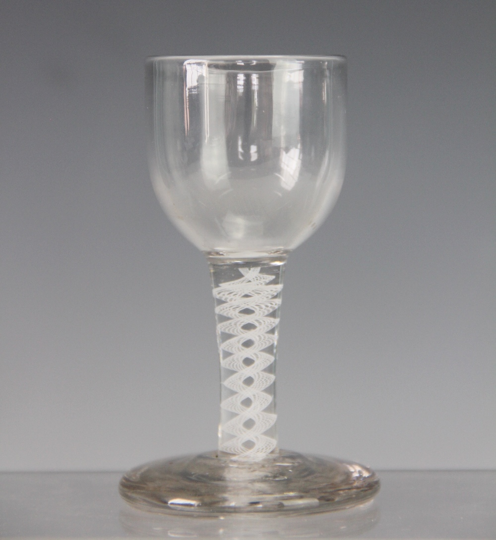 A late 18th century style glass drinking glass, with double opaque twist stem, on a thick foot,