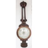 A Victorian carved walnut wheel barometer, with silvered dial and inset thermometer,