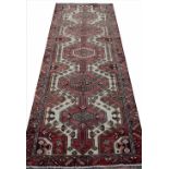 A Caucasian wool runner, worked with five geometric panels against a cream ground,