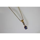 A diamond and tanzanite set 18ct gold necklace pendant and attached fine chain,